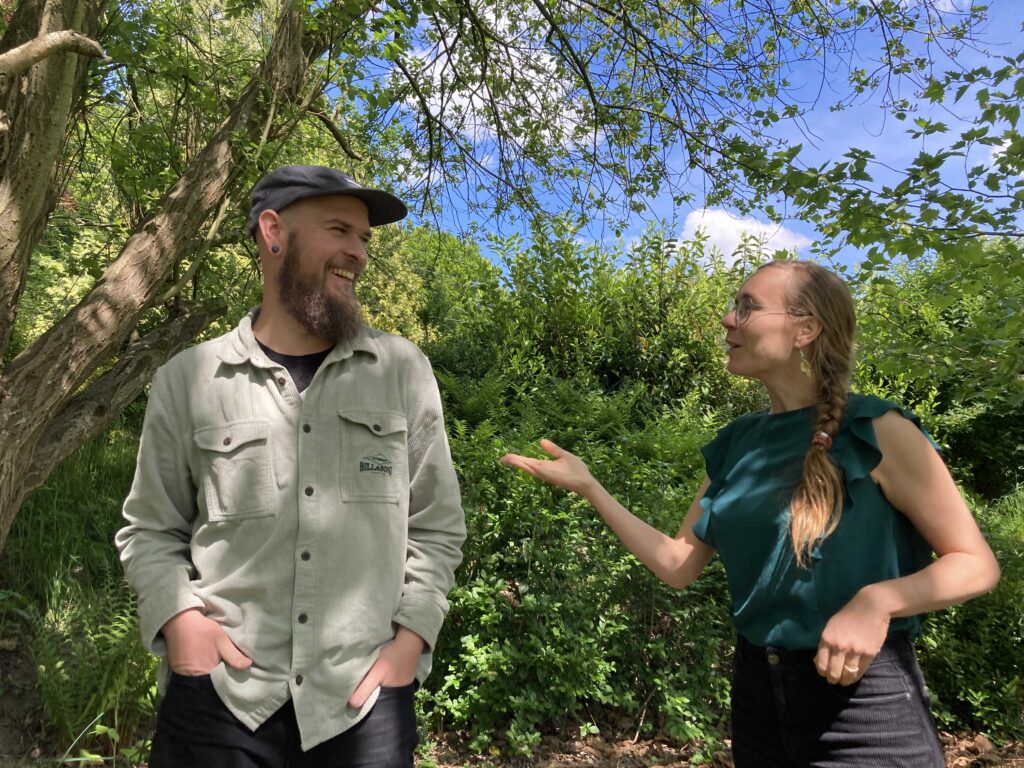 Foto van Dennis Hamer en Carli Coenen in de tuin van Station Ellecom, in gesprek. 